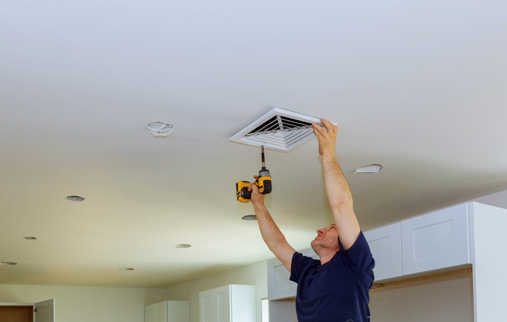installateur brengt ventilatie aan