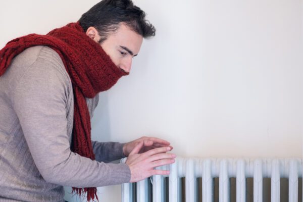 man met shawl bij koude verwarming